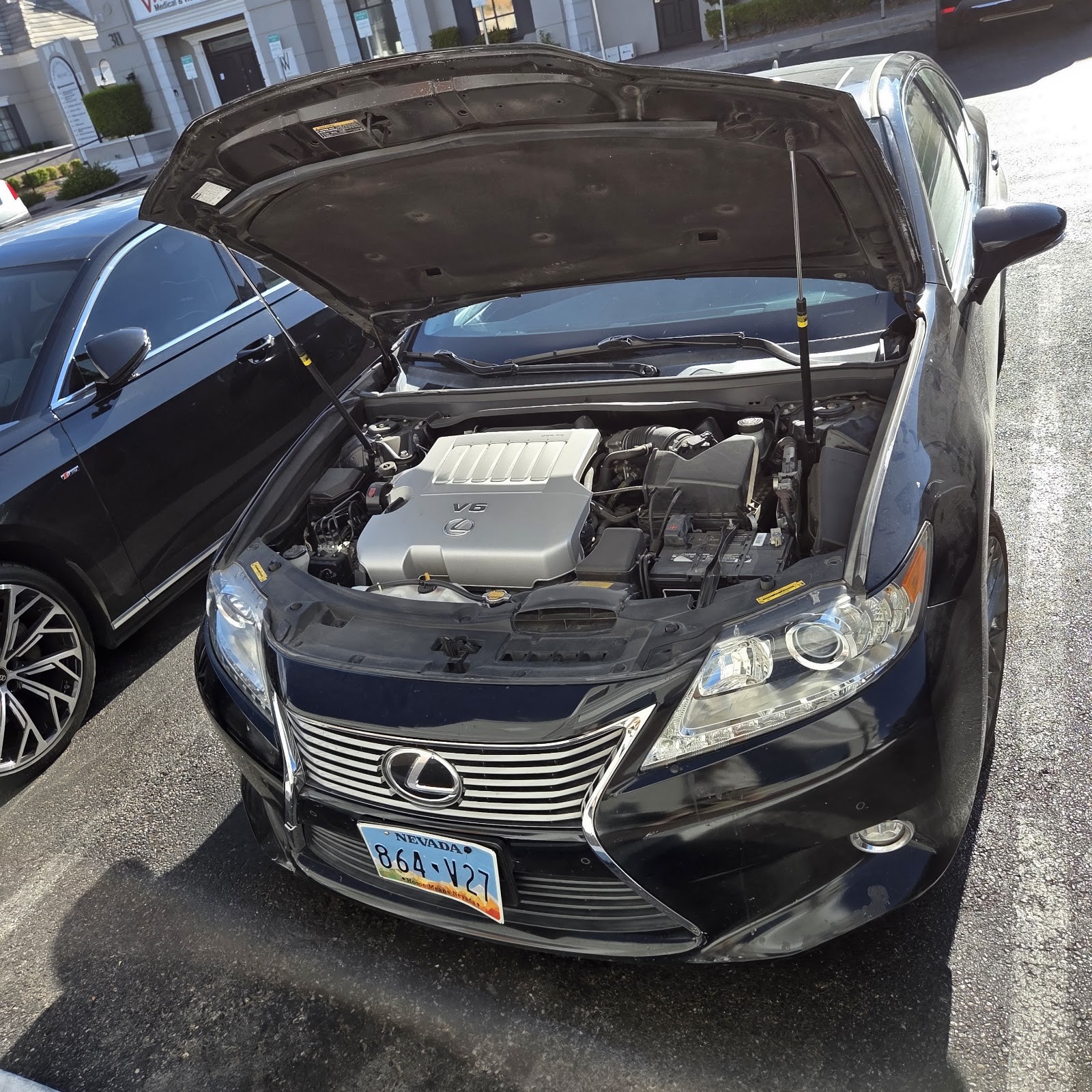 Black Lexus ES with hood open showing V6 engine during a service call